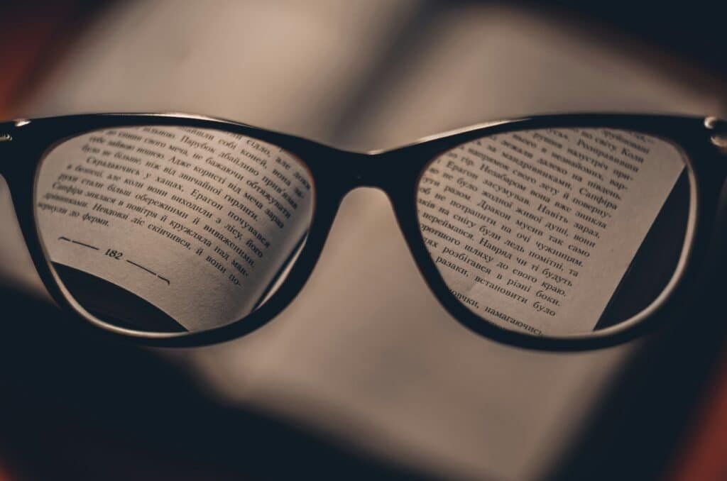 Reading glasses on printed pages illustrating the importance of reading insurance policy terms