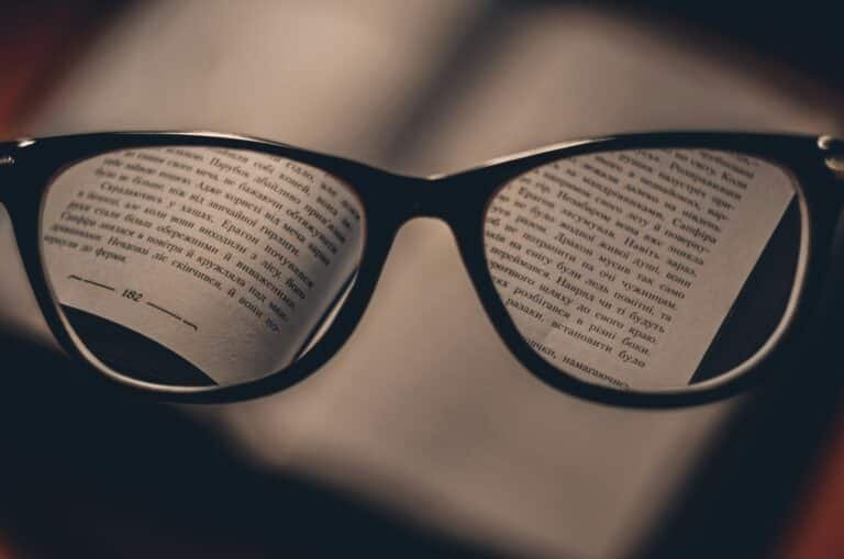 Reading glasses on printed pages illustrating the importance of reading insurance policy terms